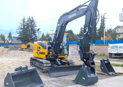 Hydraulic excavator with cleanup bucket, heavy duty bucket, and progressive thumb.