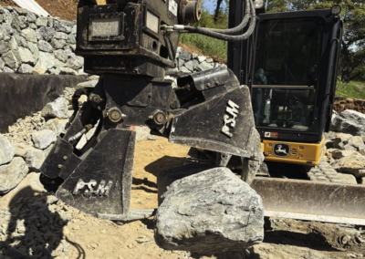 Excavator clamshell grapple with rock in quarry